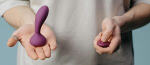 man holding a purple butt plug